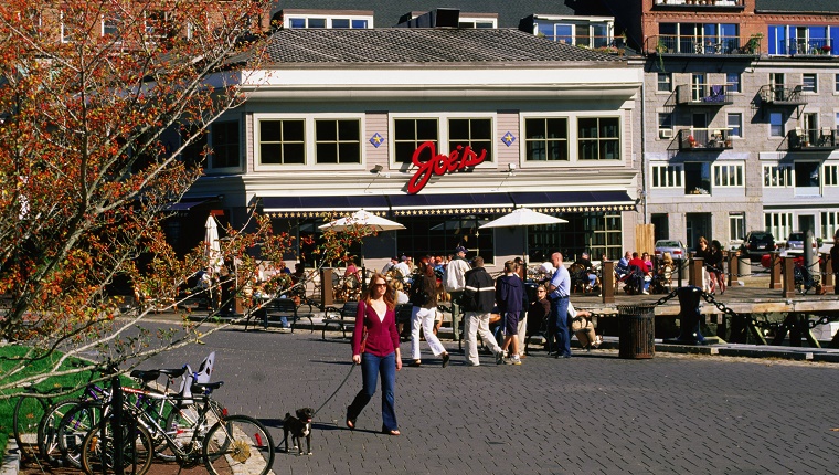 A woman walks her dog in front of Joe's restaurant in Boston.