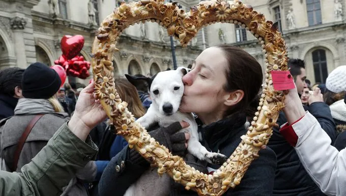 woman kissing dog at festival