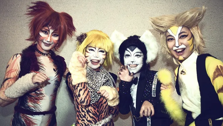 Four friends dressed as cats pose for the camera.