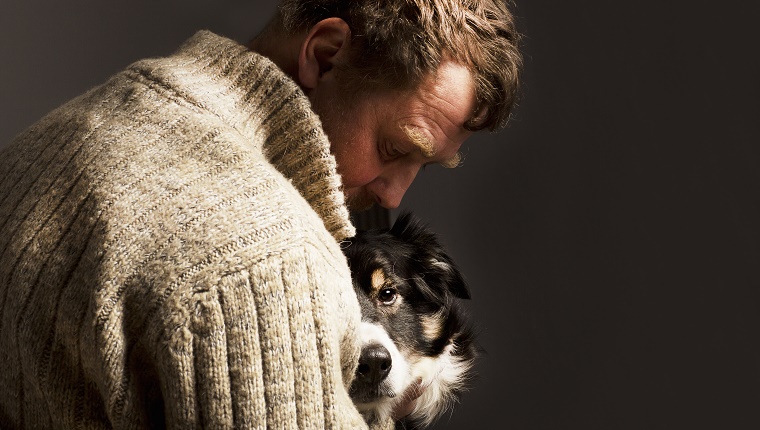man embracing dog