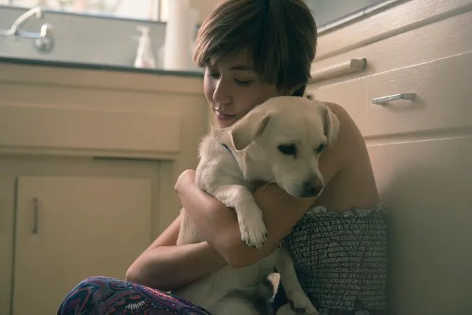 Japanese american female holding a dog.