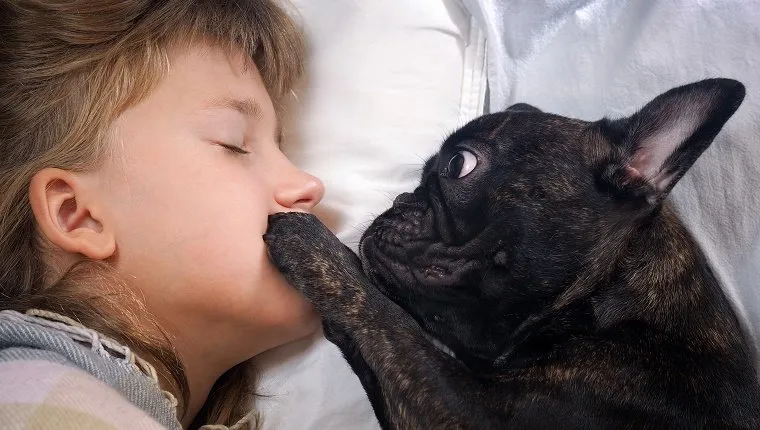 Dog places paw on girl's mouth