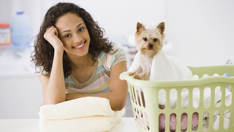 Mixed race teenage girl in laundry room with dog
