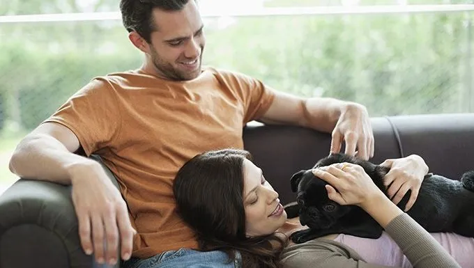 man, woman, and dog on couch
