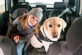 10 years old girl and her yellow labrador sitting on the back seat of a car. Cluj-Napoca, Transylvania, Romania