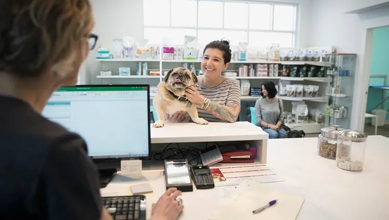 Woman with dog checking in veterinarian clinic reception