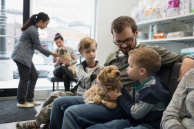 Father and sons waiting with dog veterinarian lobby