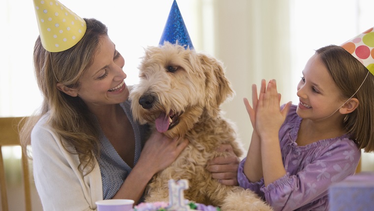 Mother and daughter giving dog birthday party