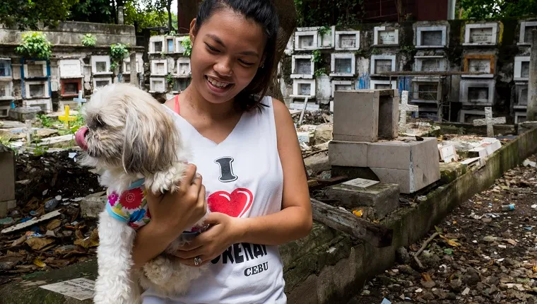 Young woman with her dog, at Calamba Cemetery, Cebu City, Cebu, Philippines