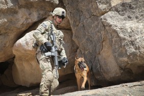 KANDAHAR, AFGHANISTAN - FEBRUARY 28: SPC Daniel Jackson from Centralia, Kansas and his dog Bailey with the 904th Military Police Detachment search through caves looking for weapons caches during a patrol with the U.S. Army's 4th squadron 2d Cavalry Regiment on February 28, 2014 near Kandahar, Afghanistan. Defense Secretary Chuck Hagel announced recently he is making preparations for a complete military withdrawal from Afghanistan because Afghanistan President Hamid Karzai continues to refuse to sign the Bilateral Security Agreement. Fourth squadron 2d Cavalry Regiment is responsible for defending Kandahar Airfield against rocket attacks from insurgents. (Photo by Scott Olson/Getty Images)