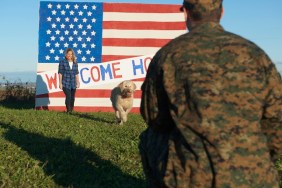 Returning Caucasian soldier greeting wife and dog