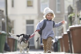 Young child running with dog