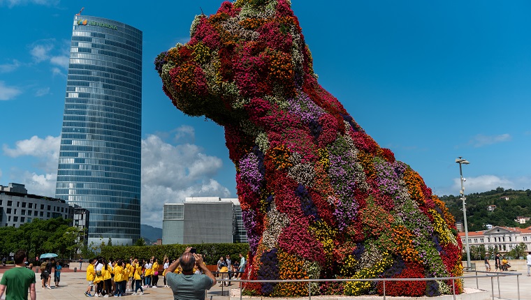 BILBAO, VIZCAYA, SPAIN - 2019/07/30: Jeff Koons Puppy dog sculpture in Guggenheim museum next to Iberdrola tower. 