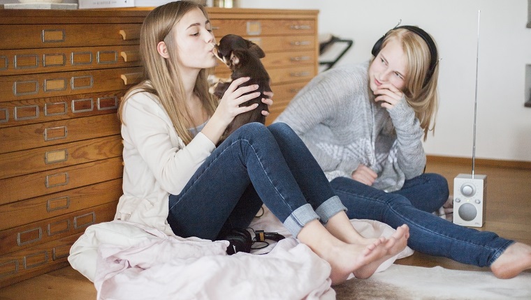 Sisters in room with radio and dog