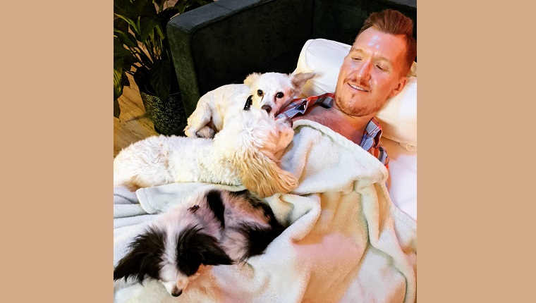 Kevin snuggling with his dogs