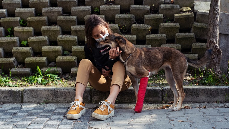 A mid adult woman in the process of adopting an injured dog from a shelter.