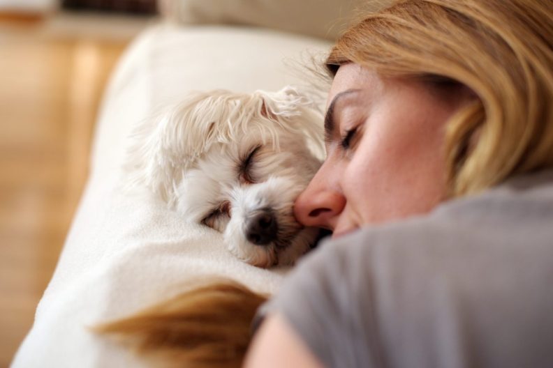 woman sleeping in on the weekend with dog in bed