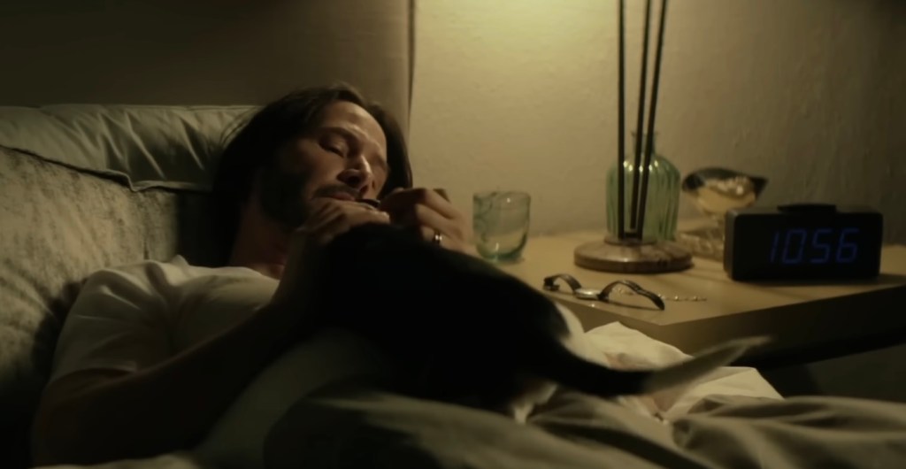 John Wick in bed with his Beagle puppy, Daisy, lying on his chest.