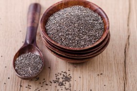 Stack of wooden bowl with chia seeds and wooden spoon on wood