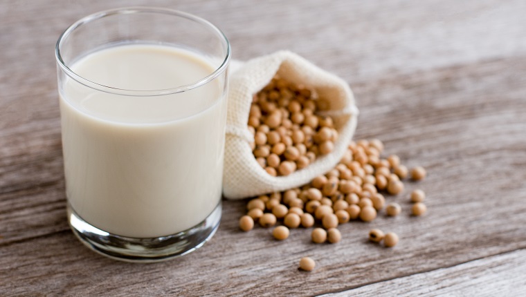 Glass of soy milk isolated on wooden table background.