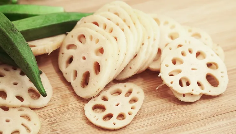 Lotus root finely cut onto thin slices with few okra fruits in behind