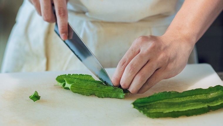 Hands cutting winged bean