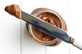 chocolate spread with knife on white table