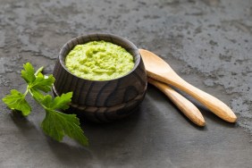 Light appetizer, green horseradish wasabi in a wooden saucepan. Dark gray background. Rustic style