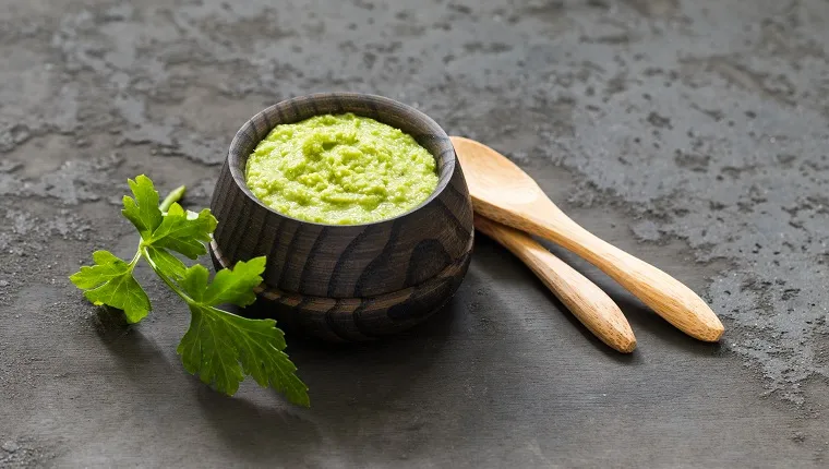 Light appetizer, green horseradish wasabi in a wooden saucepan. Dark gray background. Rustic style