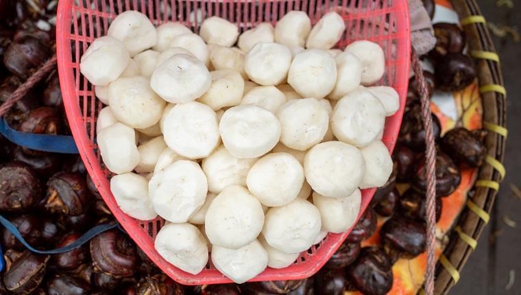 water chestnuts selling in vendor's carrying basket