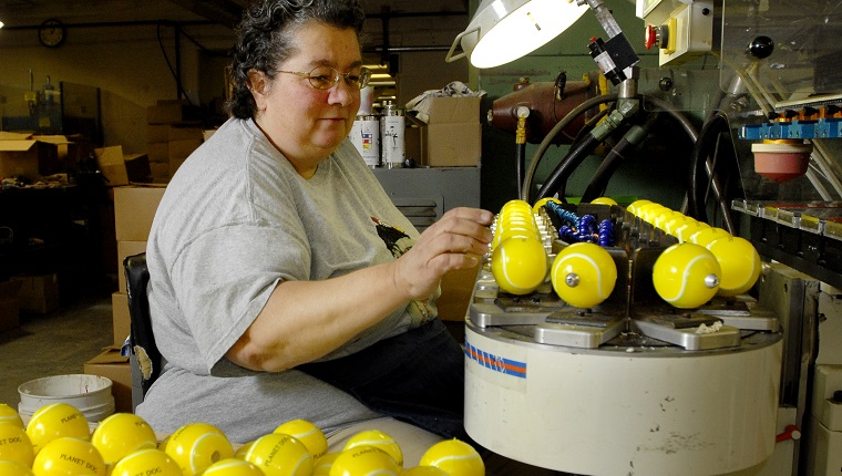PHOTO BY GORDON CHIBROSKI, STAFF PHOTOGRAPHER. On Friday, October 26, 2007 Helene Gendron, a Print Operator for G&G Manufacturing in Springvale marks Planet Dog on a multitude of yellow scented toy balls made from recycled and all natural materials. They are part of the Orbee-tuff series of scented toys at Planet Dog 