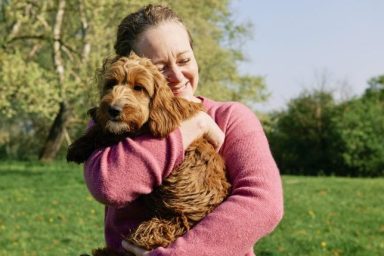 woman hugging dog springtime pet care tips