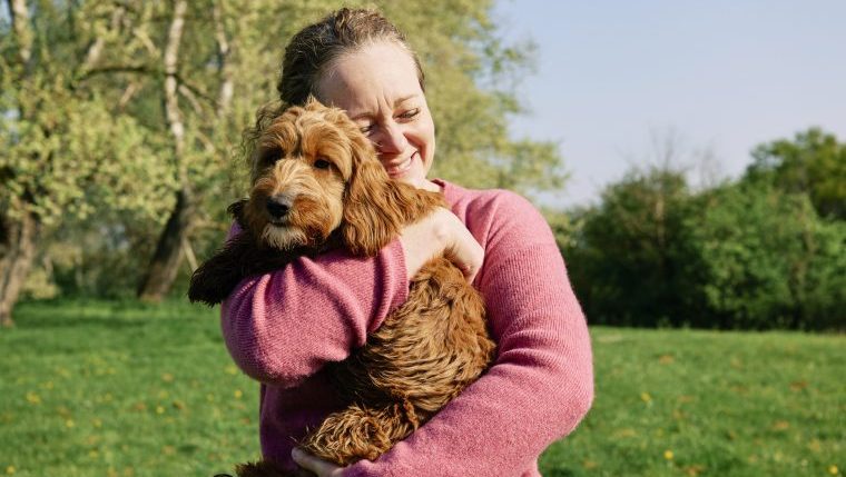 woman hugging dog springtime pet care tips