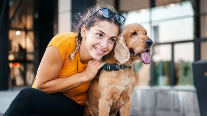 woman hugging dog sitting