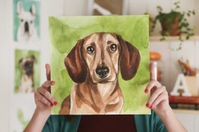 woman holding up a custom dog portrait