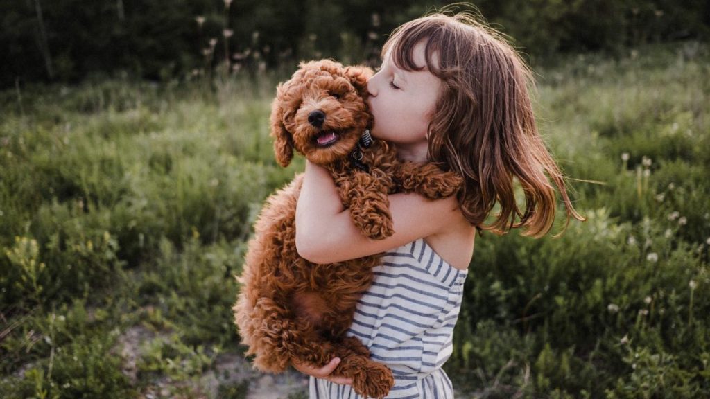 little girl hugging puppy teaching children how to be gentle with dogs