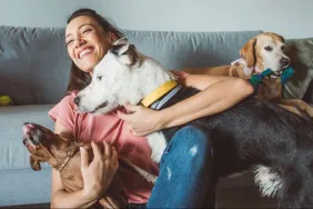 young female pet sitter hugging dogs how to prepare for pet sitter