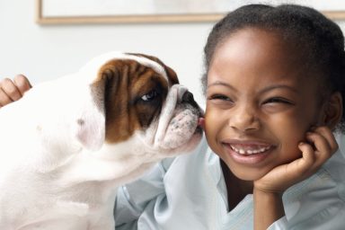 dog giving little girl kiss on the cheek benefits of dog ownership for kids