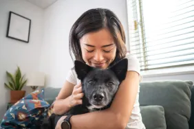 smiling woman hugs dog after foster fail