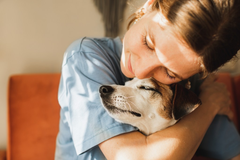 Woman hugging her pet dog, experiencing a mental health boost from petting her pooch.