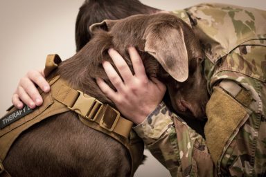 A soldier hugging a war dog, one of the many pooches for whom the Knoxville Memorial March was organized.