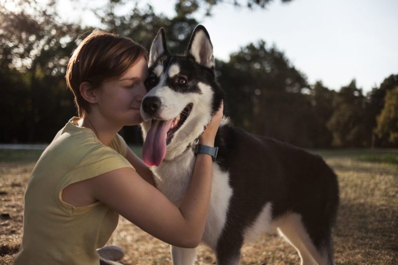 young woman hugs emotional support Husky dog