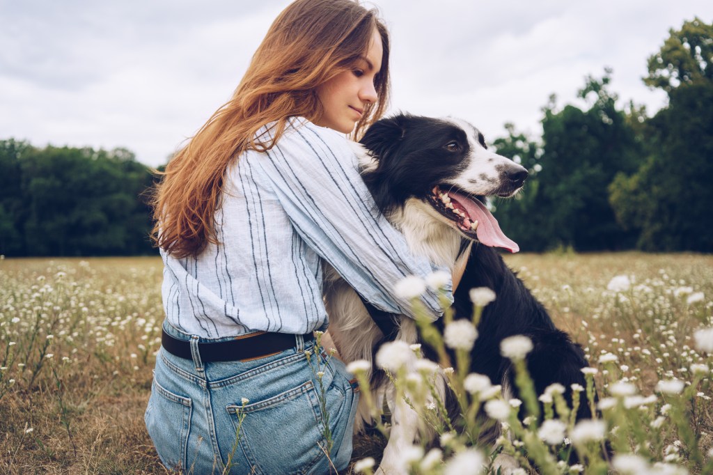 Young woman with cheerful Border Collie outdoors.