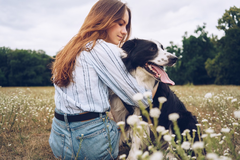 Young woman with a joyful Border Collie outdoors.