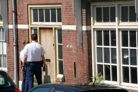 Two police officers waiting outside an apartment, like the one in Boston where police find a decomposing dog.