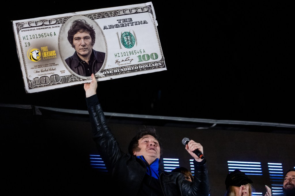 CORDOBA, ARGENTINA - NOVEMBER 16: Presidential candidate of La Libertad Avanza Javier Milei holds a hundred dollar bill with his face on it during his closing rally ahead of Sunday runoff on November 16, 2023 in Cordoba, Argentina. (Photo by Tomas Cuesta/Getty Images)