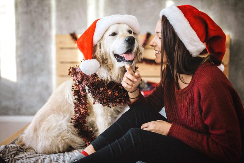 Young woman celebrating Christmas with her dog.