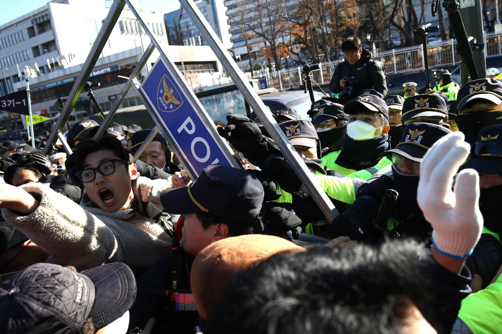 SEOUL, SOUTH KOREA - NOVEMBER 30: Dogs farmers scuffle with police officers during a protest, demanding the government scrap plans to pass a bill to enforce a ban on the consumption of dog meat, in front of Presidential office on November 30, 2023 in Seoul, South Korea. The farmers argued that banning the controversial dog meat from menus across the country would deprive them of their livelihoods. About a week ago, when the South Korean government announced its plan to introduce a ban on dog meat, animal rights organisations celebrated. (Photo by Chung Sung-Jun/Getty Images)