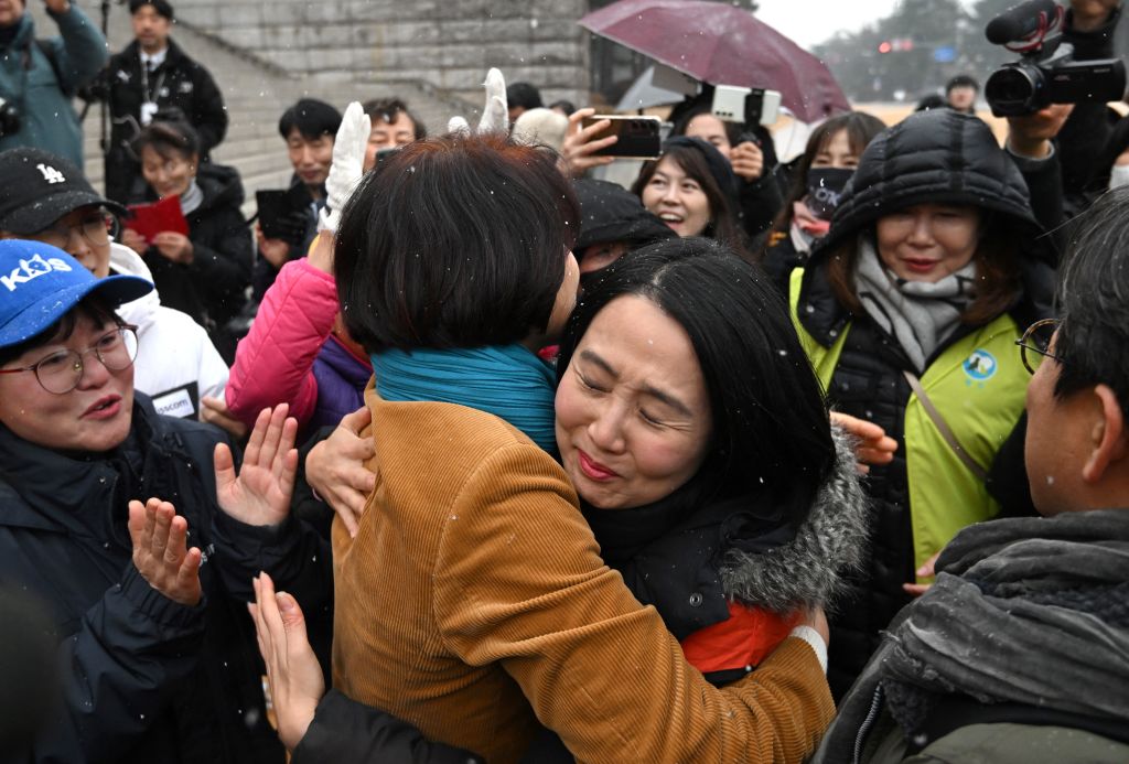 South Korean lawmaker Han Jeong-ae (centre L) celebrates with animal rights activists during a rally welcoming a bill banning dog meat trade at the National Assembly in Seoul on January 9, 2024. South Korea's parliament on January 9, passed a bill banning breeding, slaughtering and selling dogs for their meat, a traditional practice that activists have long called an embarrassment for the country. Official support for a ban has grown under President Yoon, a self-professed animal lover who has adopted several stray dogs and cats with First Lady Kim -- who is herself a vocal critic of dog meat consumption. (Photo by Jung Yeon-je / AFP) (Photo by JUNG YEON-JE/AFP via Getty Images)