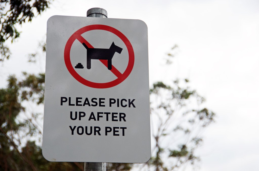 A 'please pick up after your pet' sign on the street, the Upper East Side plans to put up such signs along sidewalks to tackle its dog poo problem